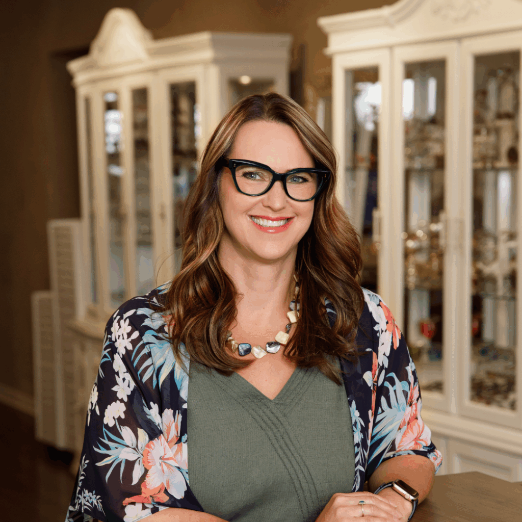 Alana from Inspired Eyes, smiling and wearing stylish glasses in the boutique