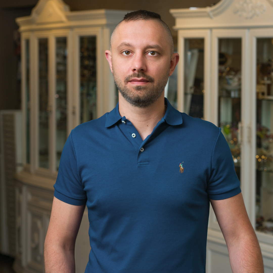 Inspired Eyes team member in a blue shirt standing in front of a white display case.