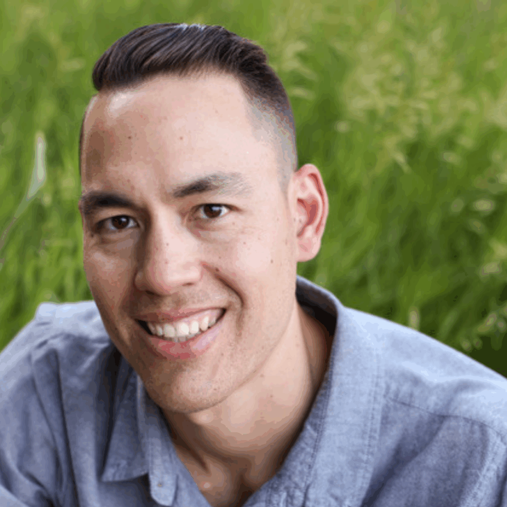 Portrait of Inspired Eyes team member in a grey shirt, smiling outdoors in natural light