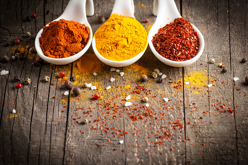 Spices in Wooden spoon. Herbs. Curry, Saffron, turmeric, rosemary, cinnamon, garlic, pepper, anise on wooden rustic background. Collection of spices and herbs. Salt, paprika. Copy space. Top view. Banner. Flat lay.
